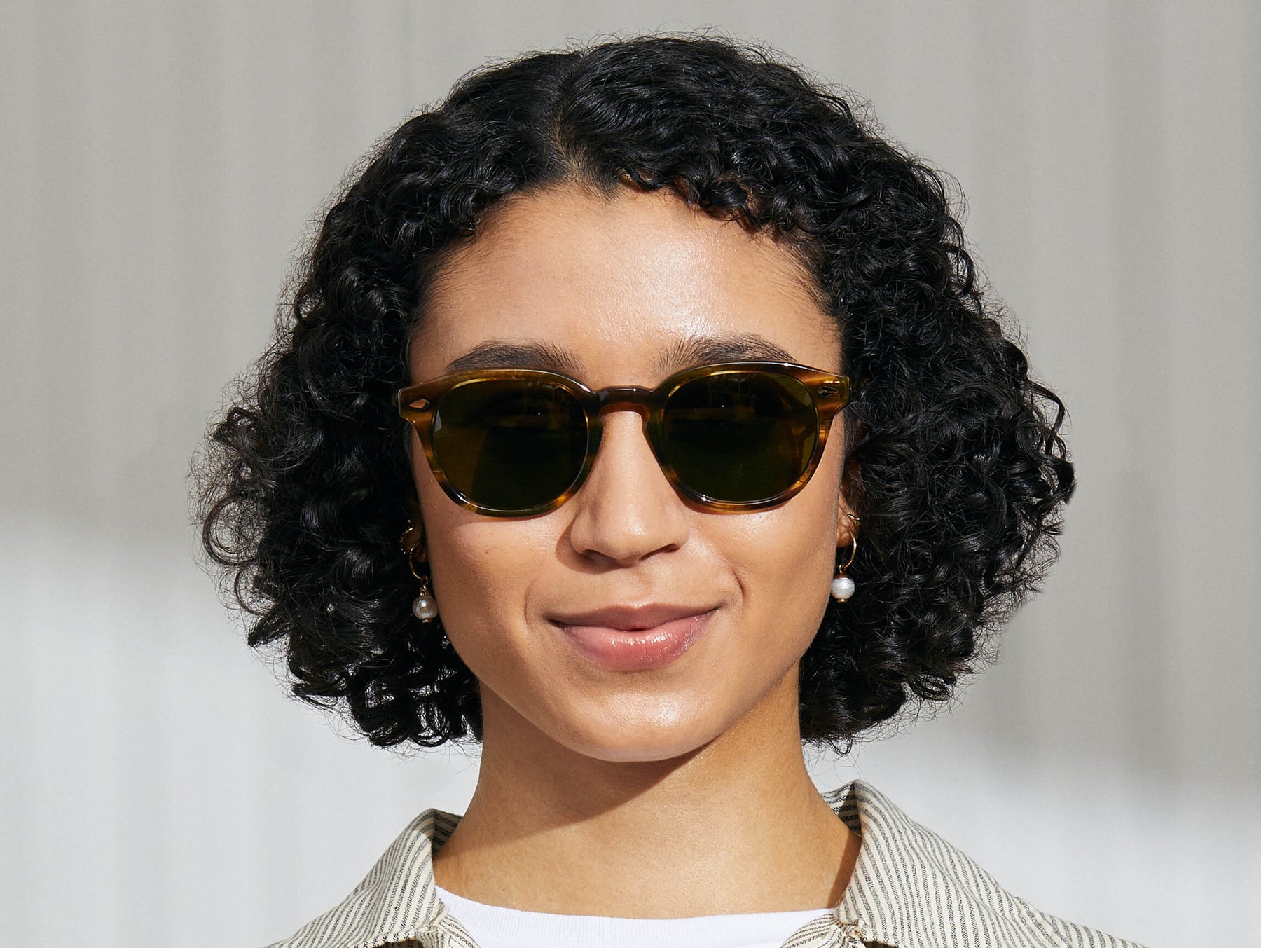 Model is wearing The LEMTOSH SUN in Bamboo in size 52 with Calibar Green Glass Lenses