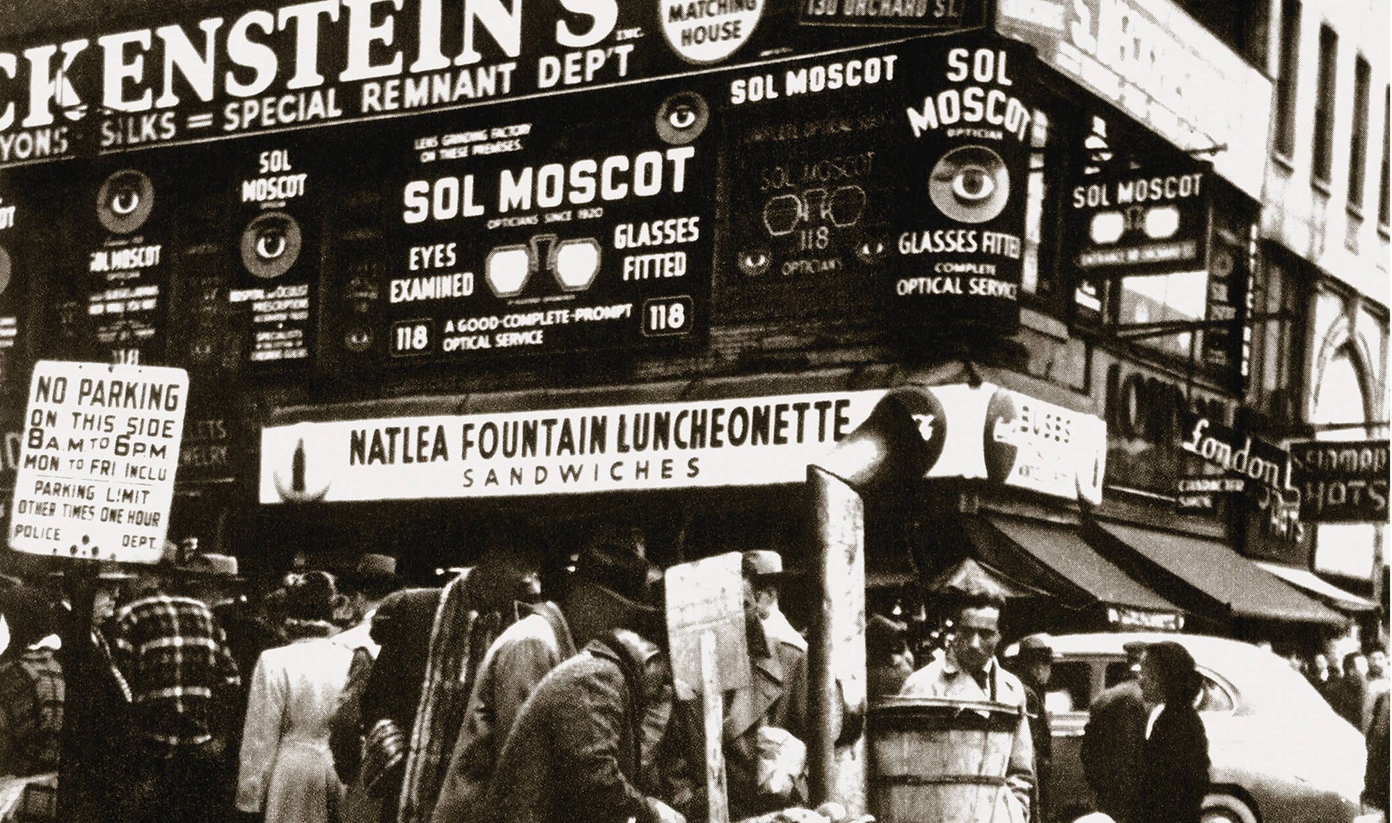 Black and white photo of Moscot store on busy street corner