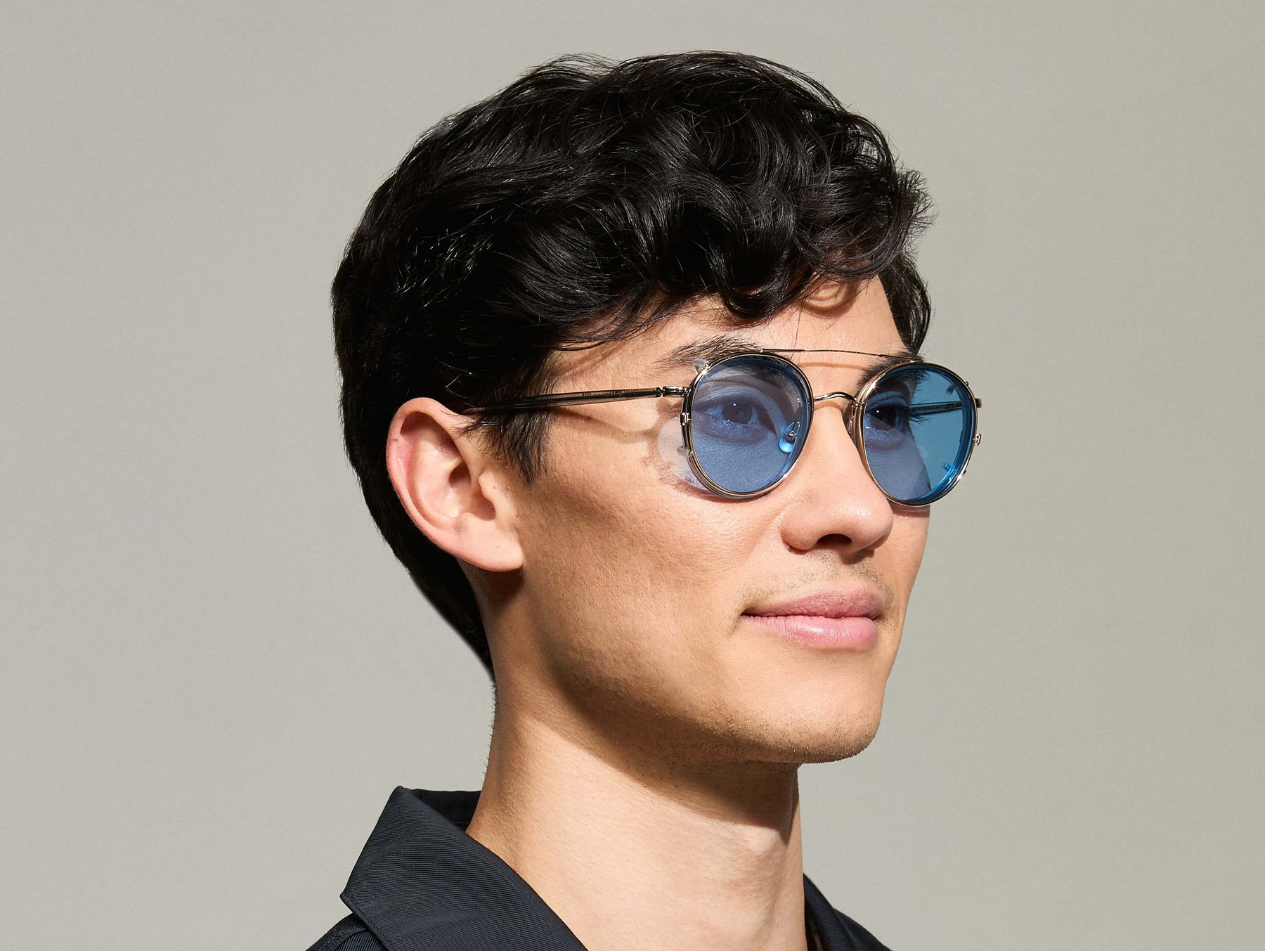 Model is wearing The ZEV CLIP in Gold in size 49 with Celebrity Blue Tinted Lenses