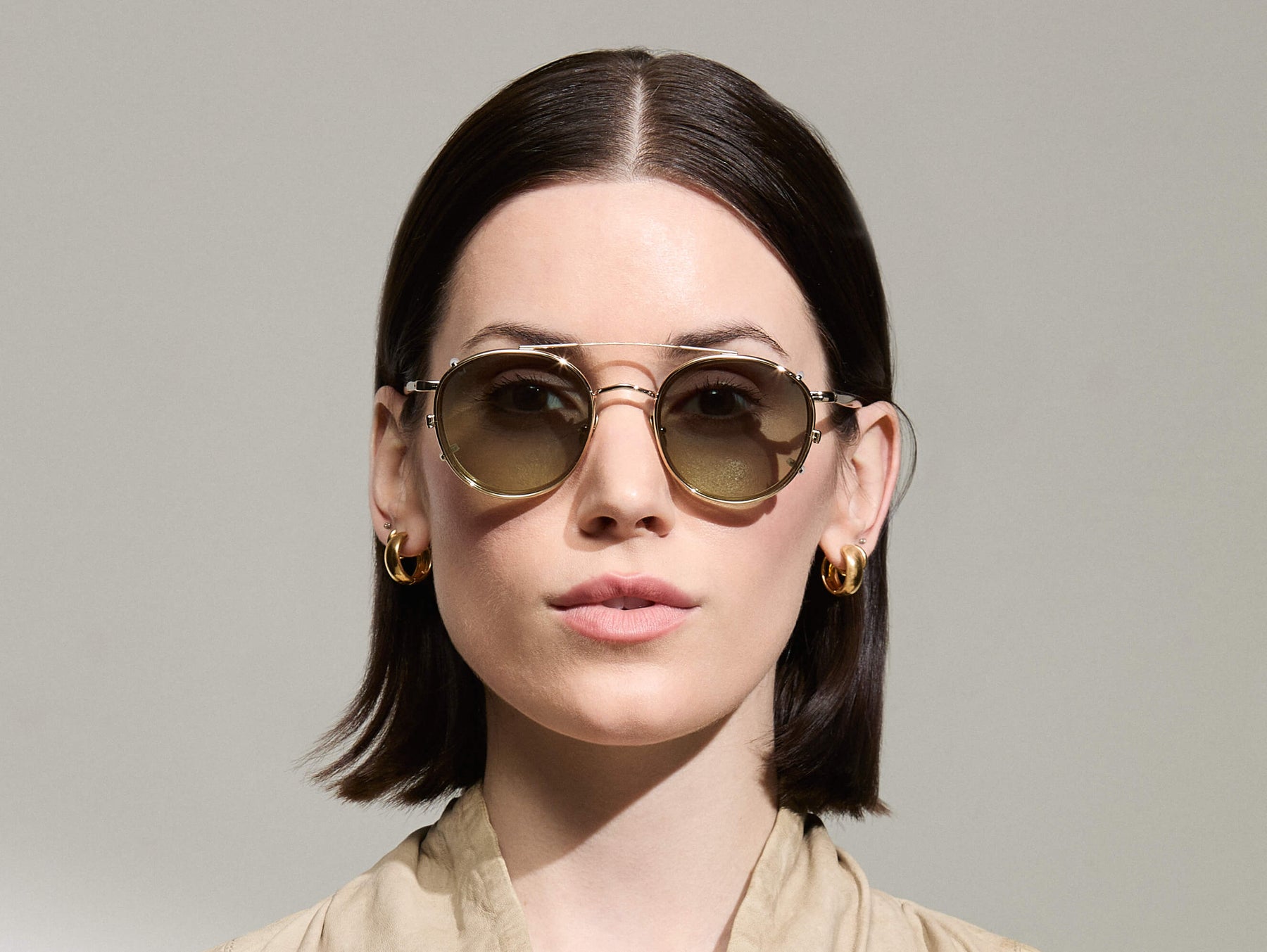 Model is wearing The ZEV CLIP in Gold in size 49 with Forest Wood Tinted Lenses