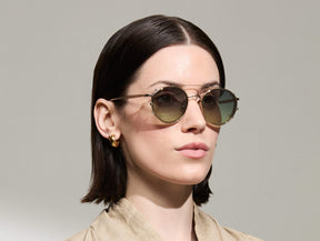 Model is wearing The ZEV CLIP in Gold in size 49 with Forest Wood Tinted Lenses