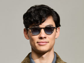 Model is wearing The ARTHUR CLIP in Gold in size 48 with Denim Blue Tinted Lenses