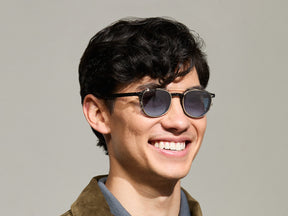 Model is wearing The ARTHUR CLIP in Gold in size 48 with Denim Blue Tinted Lenses