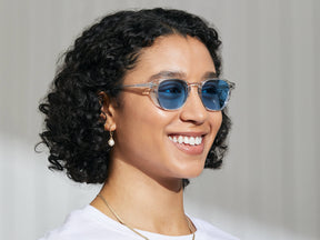 Model is wearing The ARTHUR in Crystal in size 50 with Celebrity Blue Tinted Lenses