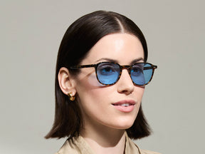 Model is wearing The ARTHUR SUN in Tortoise in size 51 with Celebrity Blue Tinted Lenses