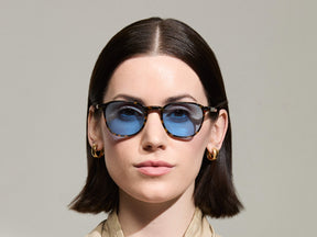 Model is wearing The ARTHUR SUN in Tortoise in size 51 with Celebrity Blue Tinted Lenses
