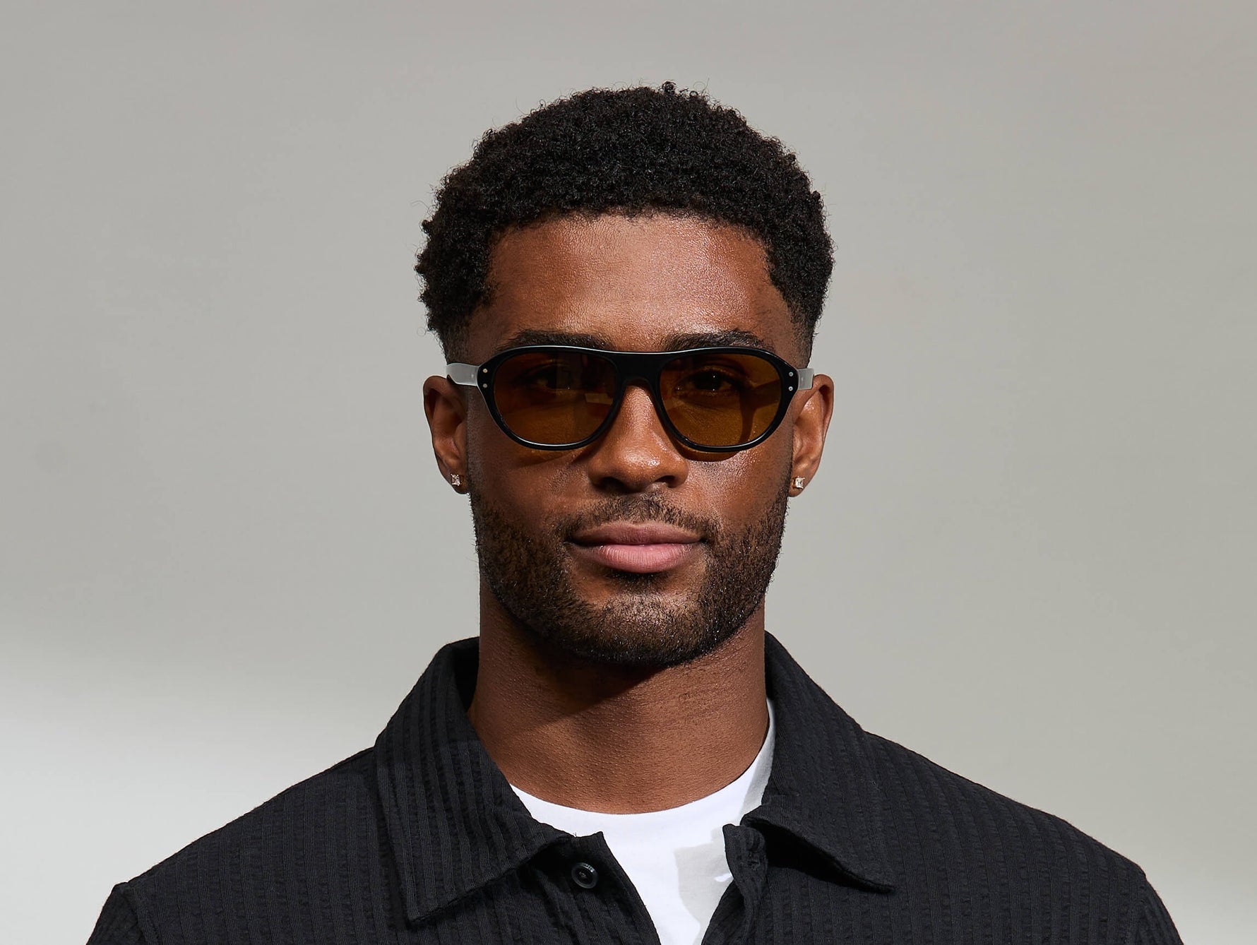 Model is wearing The AVRAM in size 54 in Black with Amber Tinted Lenses