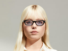 Model is wearing The BISSLE SUN in Black in size 48 with Bel Air Blue Tinted Lenses