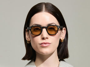 The Model is wearing The CLIPTOSH in Matte Black in size 46 with Amber Tinted Lenses