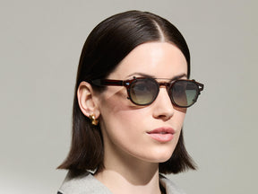 The Model is wearing The CLIPTOSH in Matte Black in size 46 with Forest Wood Tinted Lenses