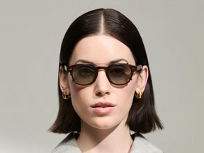 The Model is wearing The CLIPTOSH in Matte Black in size 46 with Forest Wood Tinted Lenses