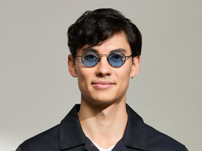 Model is wearing The COSNIC SUN in size 44 in Pine with Celebrity Blue Tinted Lenses