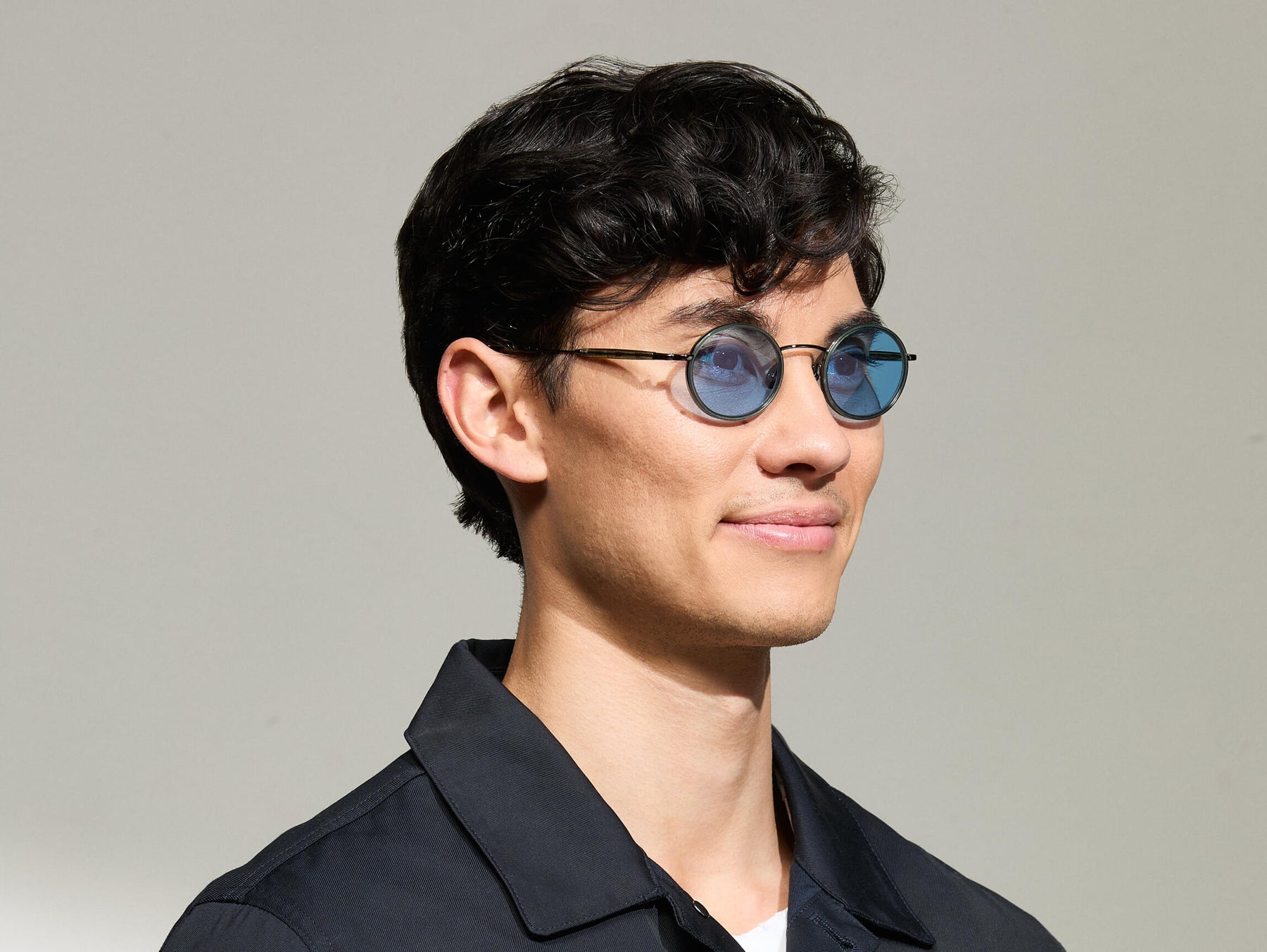 Model is wearing The COSNIC SUN in size 44 in Pine with Celebrity Blue Tinted Lenses