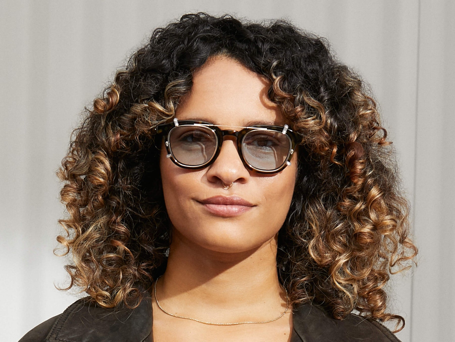 Model is wearing The DAHVEN CLIP in Gold in size 47 with Bel Air Blue Tinted Lenses