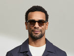 Model is wearing The DOLT in Grey-Brown Fade in size 46 with AMBER+ Lenses