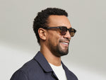 Model is wearing The DOLT in Grey-Brown Fade in size 46 with AMBER+ Lenses