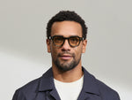 Model is wearing The DOLT in Dark Green in size 46 with AMBER+ Lenses