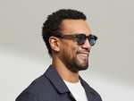 Model is wearing The DOLT in Grey-Brown Fade in size 46 with BLUE+ Lenses