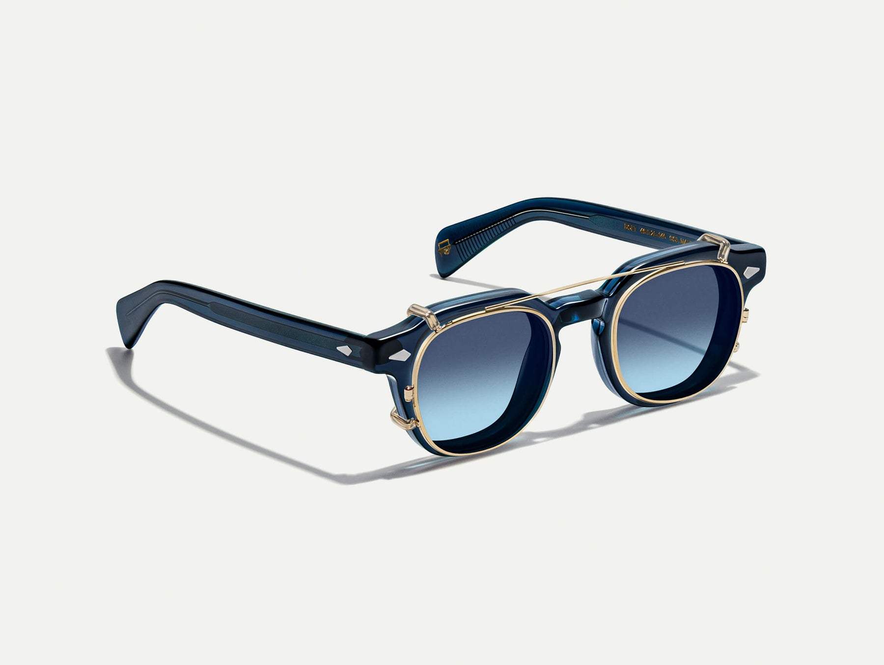 The DOLT CLIP in Gold with Denim Blue Tinted Lenses