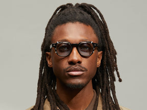 Model is wearing The DOLT CLIP in Gold in size 46 with Bel Air Blue Tinted Lenses