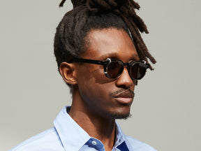 Model is wearing The DOLT CLIP in Gold in size 46 with G-15 Tinted Lenses