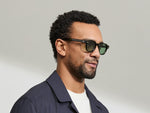 Model is wearing The DOLT in Dark Green in size 46 with GREEN+ Lenses
