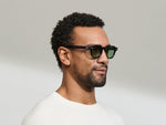 Model is wearing The DOLT in Navy in size 46 with GREEN+ Lenses