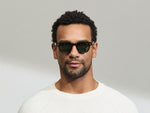 Model is wearing The DOLT in Black in size 46 with GREEN+ Lenses