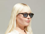 Model is wearing The DOLT SUN Limited Edition in size 46 in Bark with Blue Tinted Lenses