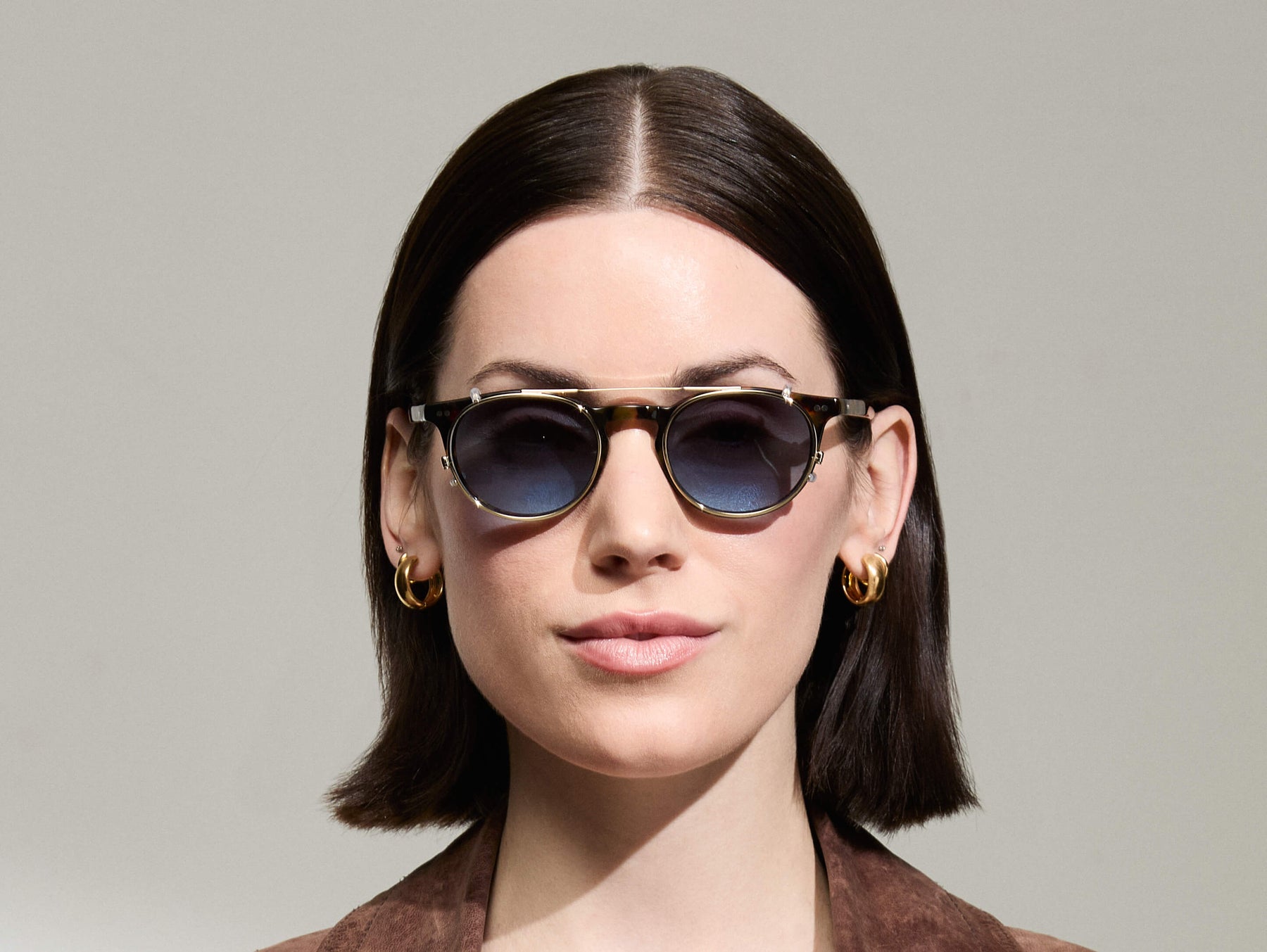Model is wearing The FRANKIE CLIP in Gold in size 48 with Denim Blue Tinted Lenses