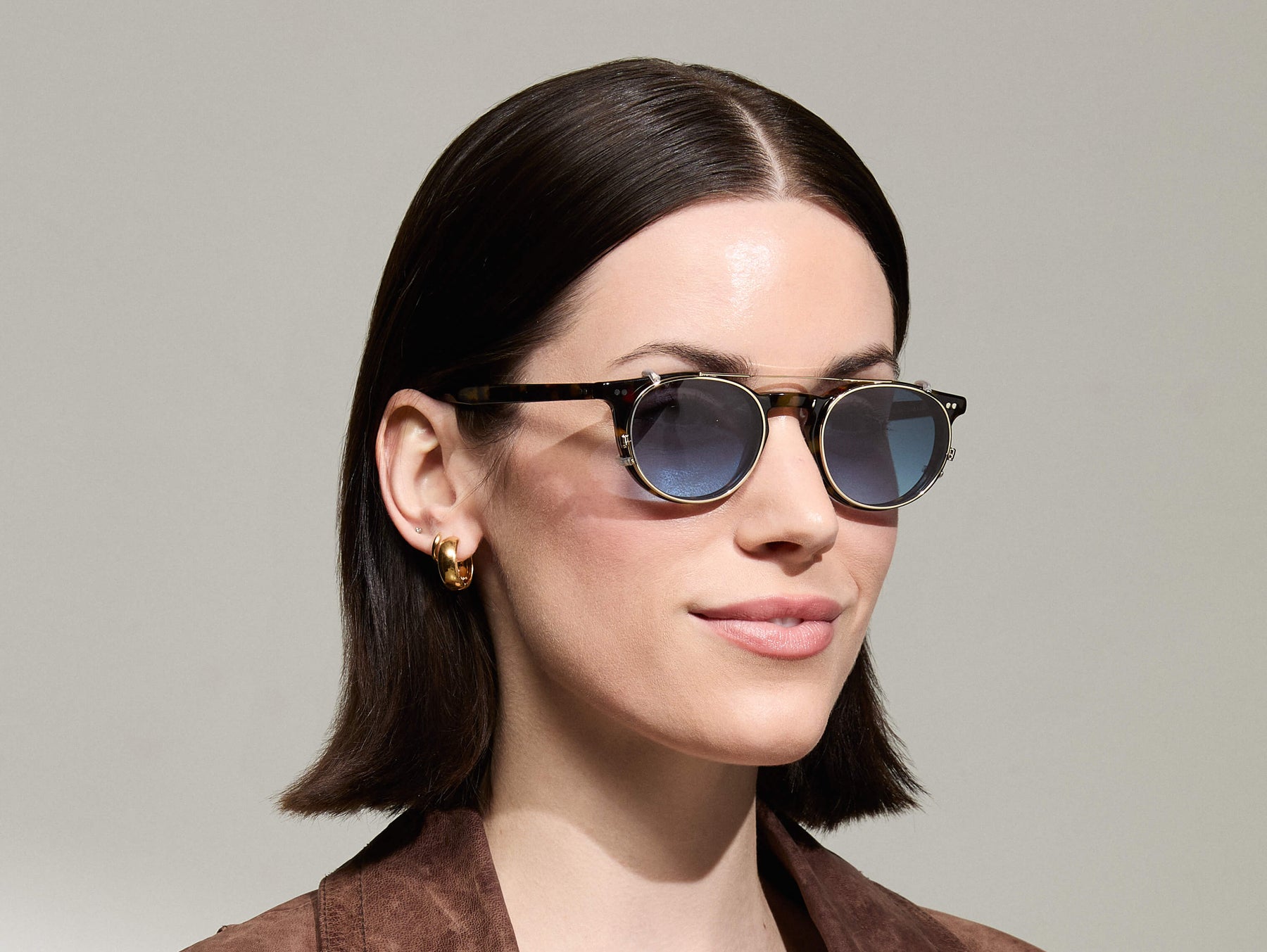Model is wearing The FRANKIE CLIP in Gold in size 48 with Denim Blue Tinted Lenses