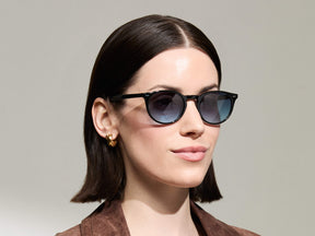 Model is wearing The FRANKIE SUN in Black in size 51 with Denim Blue Tinted Lenses