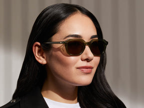 Model is wearing The GATKES SUN in Pine in size 49 with Green Lenses