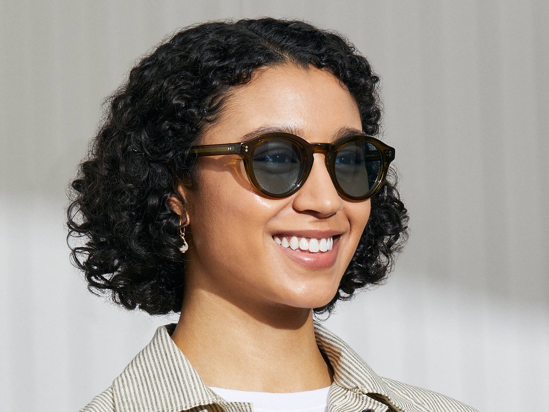 Model is wearing The KEPPE SUN in Olive Brown in size 48 with Mineral Blue Glass Lenses