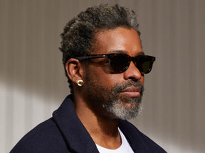 Model is wearing The KLUTZ SUN in Tortoise in size 50 with Green Lenses