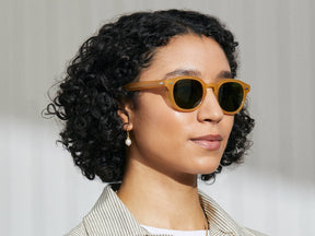 Model is wearing The LEMTOSH SUN Limited Edition in Goldenrod in size 49 with Calibar Green Glass Lenses