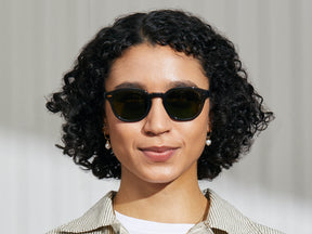 Model is wearing The LEMTOSH SUN in Grey in size 49 with G-15 Glass Lenses