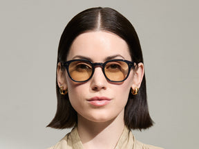 Model is wearing The LEMTOSH-TT 110 SUN in size 49 in Navy/Gold with BROWN+ Lenses
