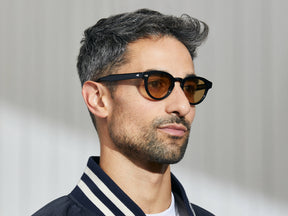 Model is wearing The MAYDELA SUN in Black in size 46 with Amber Tinted Lenses