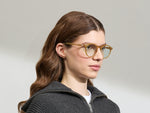 Model draagt de MILTZEN in Blonde in maat 49 met BLUE+ lenzen