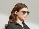 Model draagt de MILTZEN in Blonde in maat 49 met BLUE+ lenzen