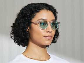 Model is wearing The MILTZEN in Crystal in size 49 with Turquoise Tinted Lenses