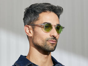 Model is wearing The MILTZEN in Crystal in size 46 with Garnet Green Tinted Lenses