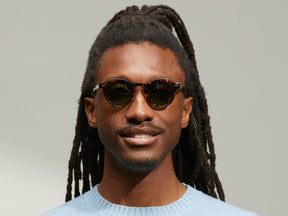 Model is wearing The MILTZEN SUN W/ METAL NOSE PADS in Tortoise in size 46 with G-15 Glass Lenses