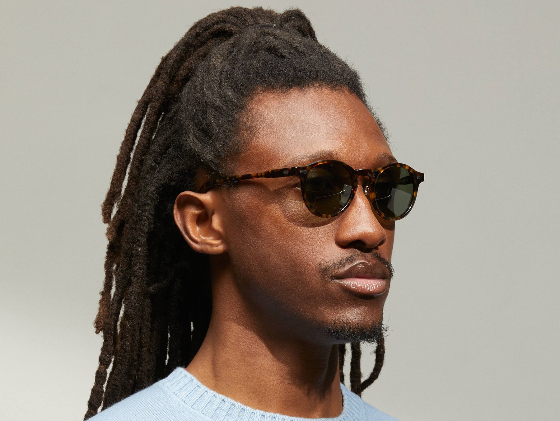 Model is wearing The MILTZEN SUN W/ METAL NOSE PADS in Tortoise in size 46 with G-15 Glass Lenses