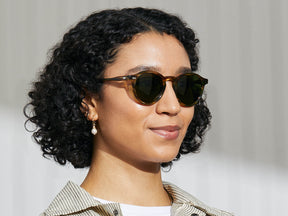 Model is wearing The MILTZEN SUN in Bamboo in size 49 with Calibar Green Glass Lenses