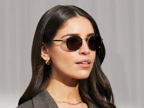 Model is wearing The MOSHA SUN in Tortoise/Gold in size 49 with G-15 Glass Lenses