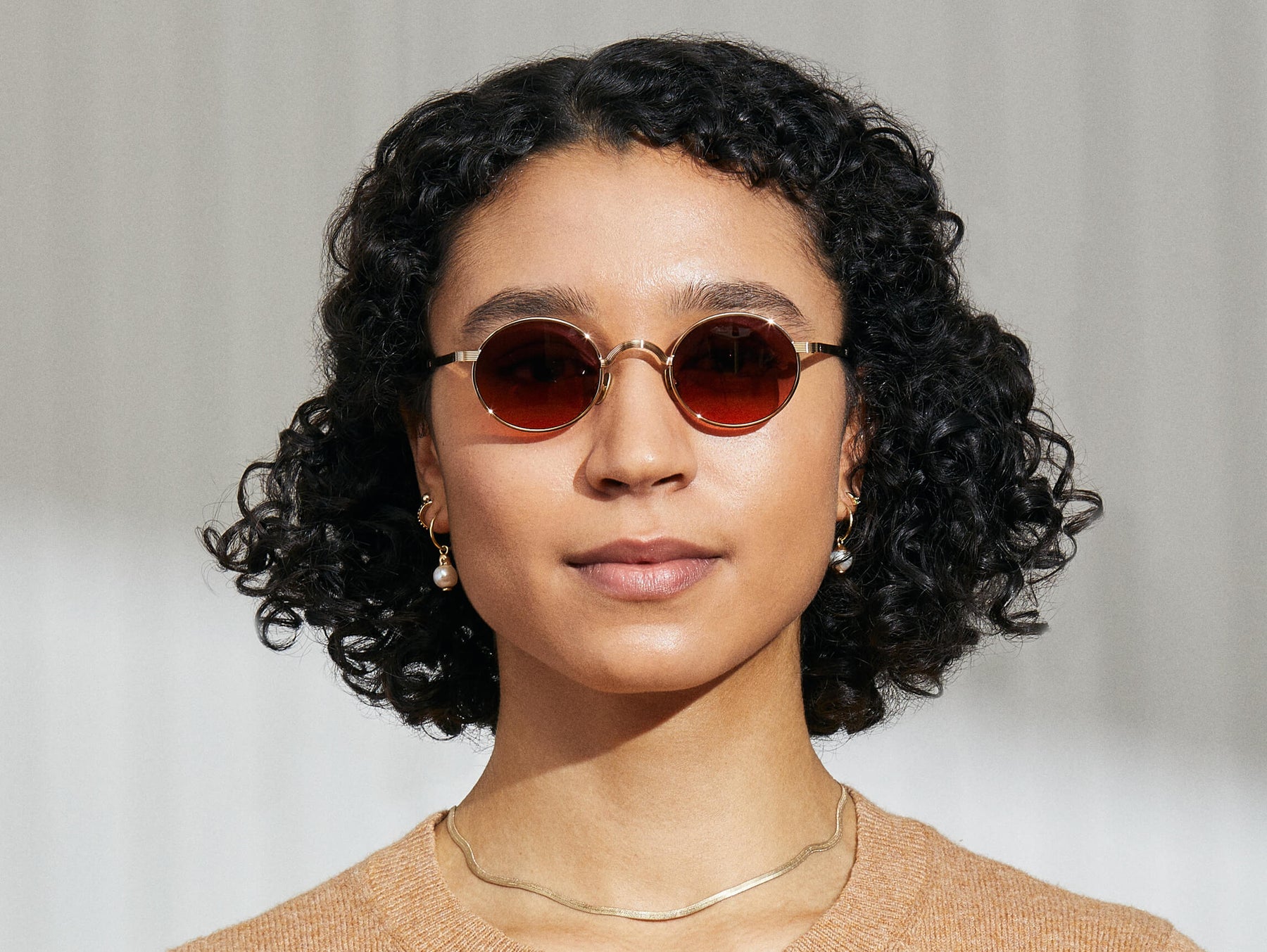 Model is wearing The MOYEL SUN in Gold in size 44 with Cabernet Tinted Lenses