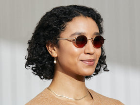 Model is wearing The MOYEL SUN in Gold in size 44 with Cabernet Tinted Lenses
