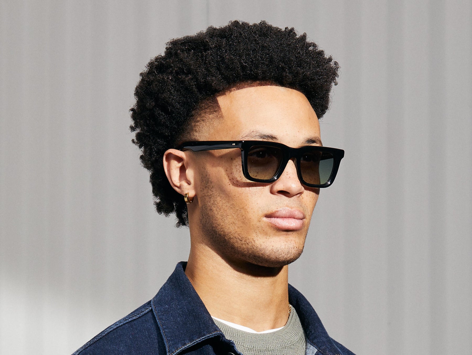 Model is wearing The RIZIK in Black in size 49 with Forest Wood Tinted Lenses